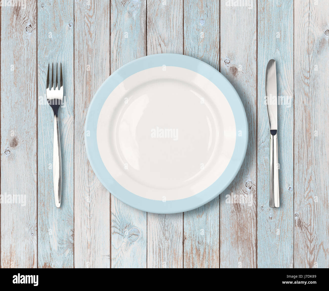 weiße leere Teller mit blauen Rand auf Holztisch Stockfoto