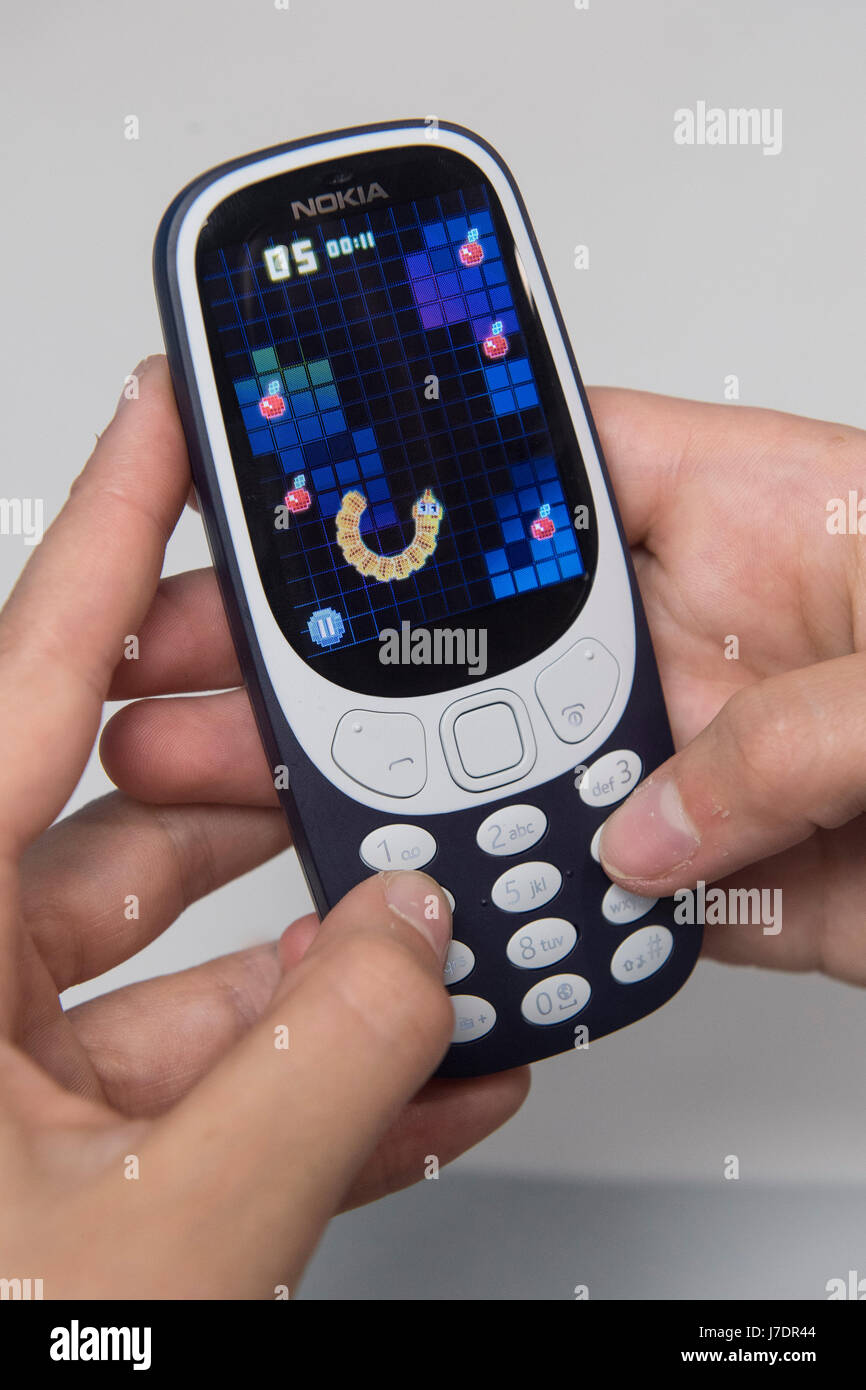Eine Person spielt die klassische mobile Spiel Snake als das neue Nokia 3310 Handy auf den Verkauf an die Carphone Warehouse auf Oxford Street, London geht. Stockfoto