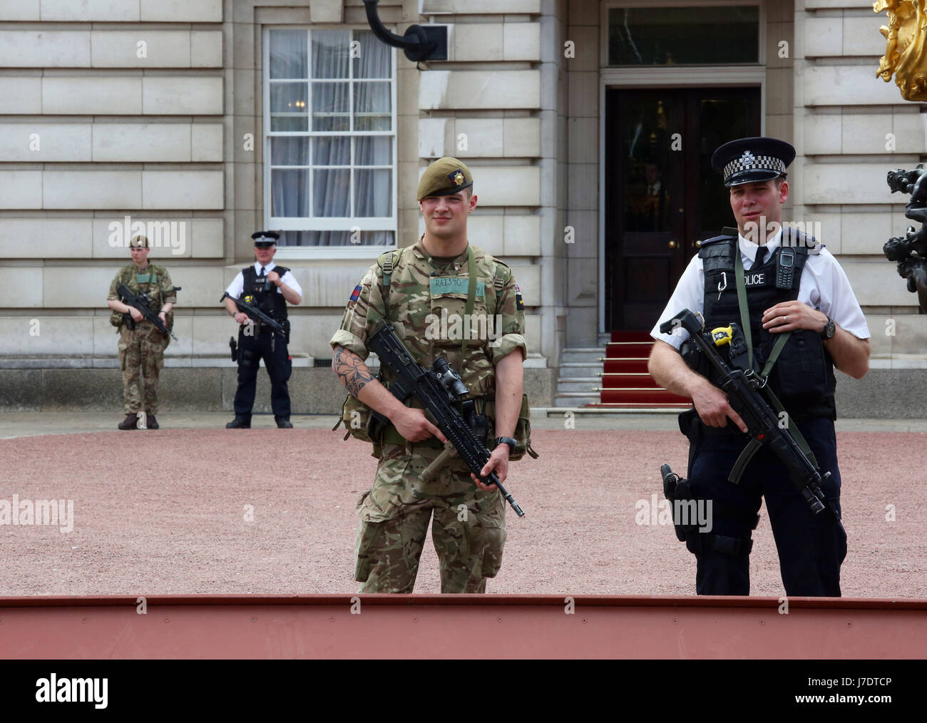 Mitglieder der Armee schließen sich Polizeibeamten vor dem Buckingham Palace, London, an, nachdem Scotland Yard angekündigt hatte, dass bewaffnete Truppen eingesetzt werden, um "Schlüsselorte" wie Buckingham Palace, Downing Street, den Palace of Westminster und Botschaften zu bewachen. Stockfoto