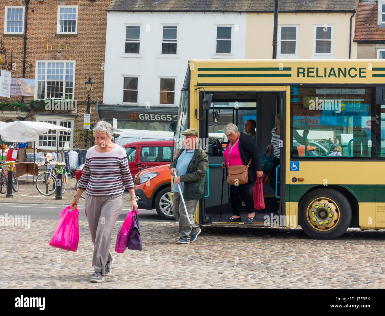 Passagiere aussteigen aus einem Reliance-Bus in der Market Square Thirsk, North Yorkshire England UK Stockfoto