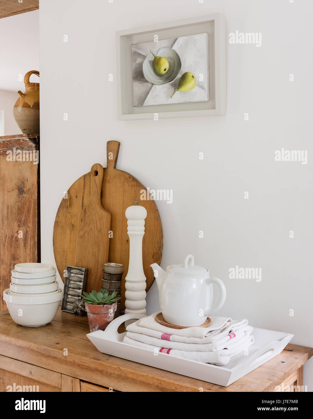 Malerei von Birnen von Emeline Watchorn über Konsole Holztisch mit Schneidebretter und Tabletts. Die Teekanne ist von Scandi Leben Stockfoto
