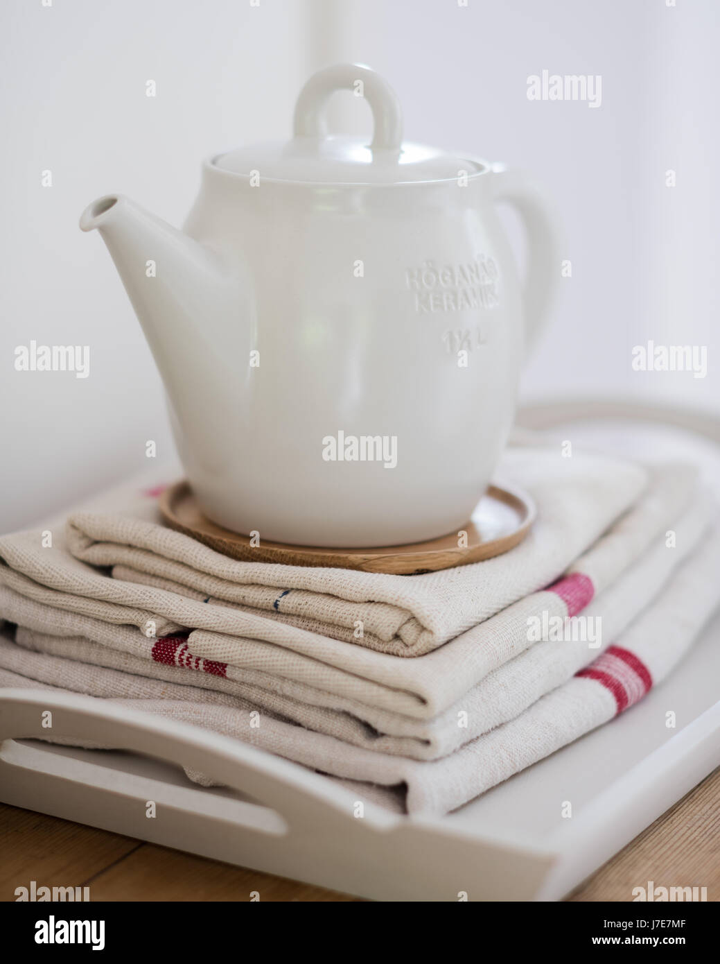 Weiße Teekanne von Scandi Leben auf gefalteten Leinen teatowels Stockfoto