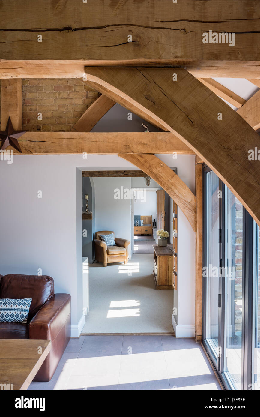 Blick vom Eichenholz umrahmt Küche durch zum Wohnzimmer mit Ledersessel Stockfoto