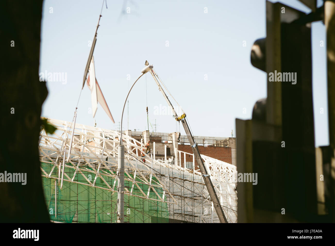 Mann im Overall-Generator fixiert auf die Höhe. Montage, arbeitet Sanierung in Höhe mit Metallstruktur, im freien gegen den Himmel Bau Stockfoto