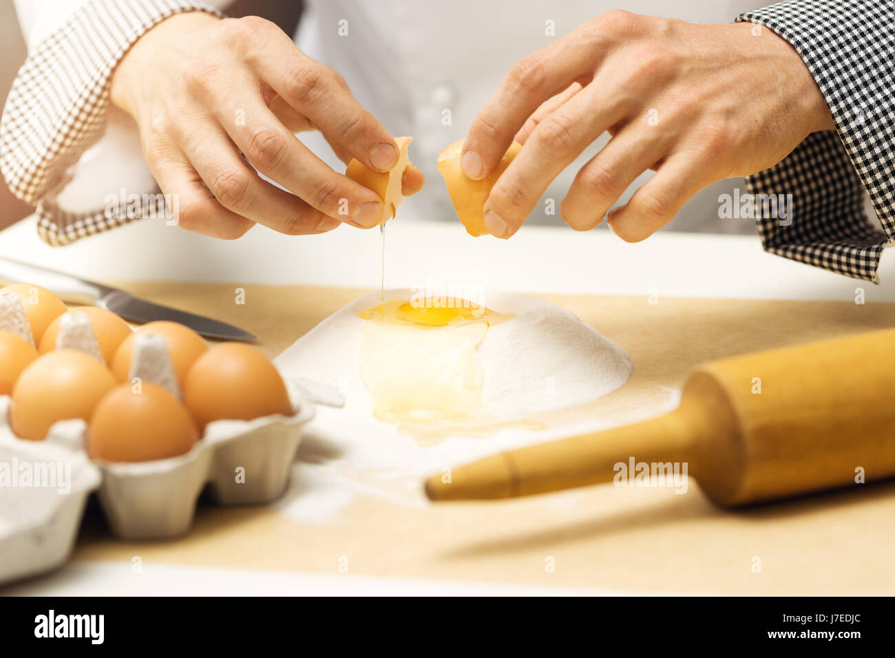 Teig - Chef knacken Ei über Mehl heap Stockfoto