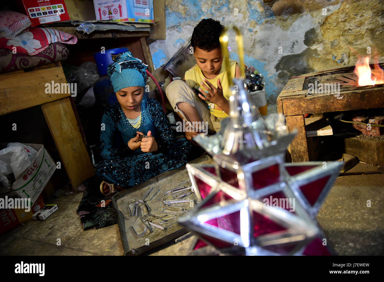 (170524)--Kairo, 24. Mai 2017 (Xinhua)--Hussein Sayyid Kinder machen traditionelle handgefertigte Laternen in ihres Vaters Werkstatt in Kairo, Ägypten, am 20. Mai 2017. Befindet sich in einem alten Gebäude in einer Straße voller Workshops in Al-Qalaa, die "die Zitadelle" auf Arabisch bedeutet unter Bezugnahme auf Kairos Saladin-Zitadelle, produziert von Sayyid Workshop bunte handgemachte Glas und Metall-Laternen in verschiedenen Größen, auf Arabisch als "Fanoos", angezeigt auf steht außerhalb der Werkstatt bekannt. Traditionelle handgefertigte Laternen dienen in der Regel als Dekoration in Ägypten während der jährlichen Monat Ramadan. (Xinhua/Zhao Dingzhe Stockfoto