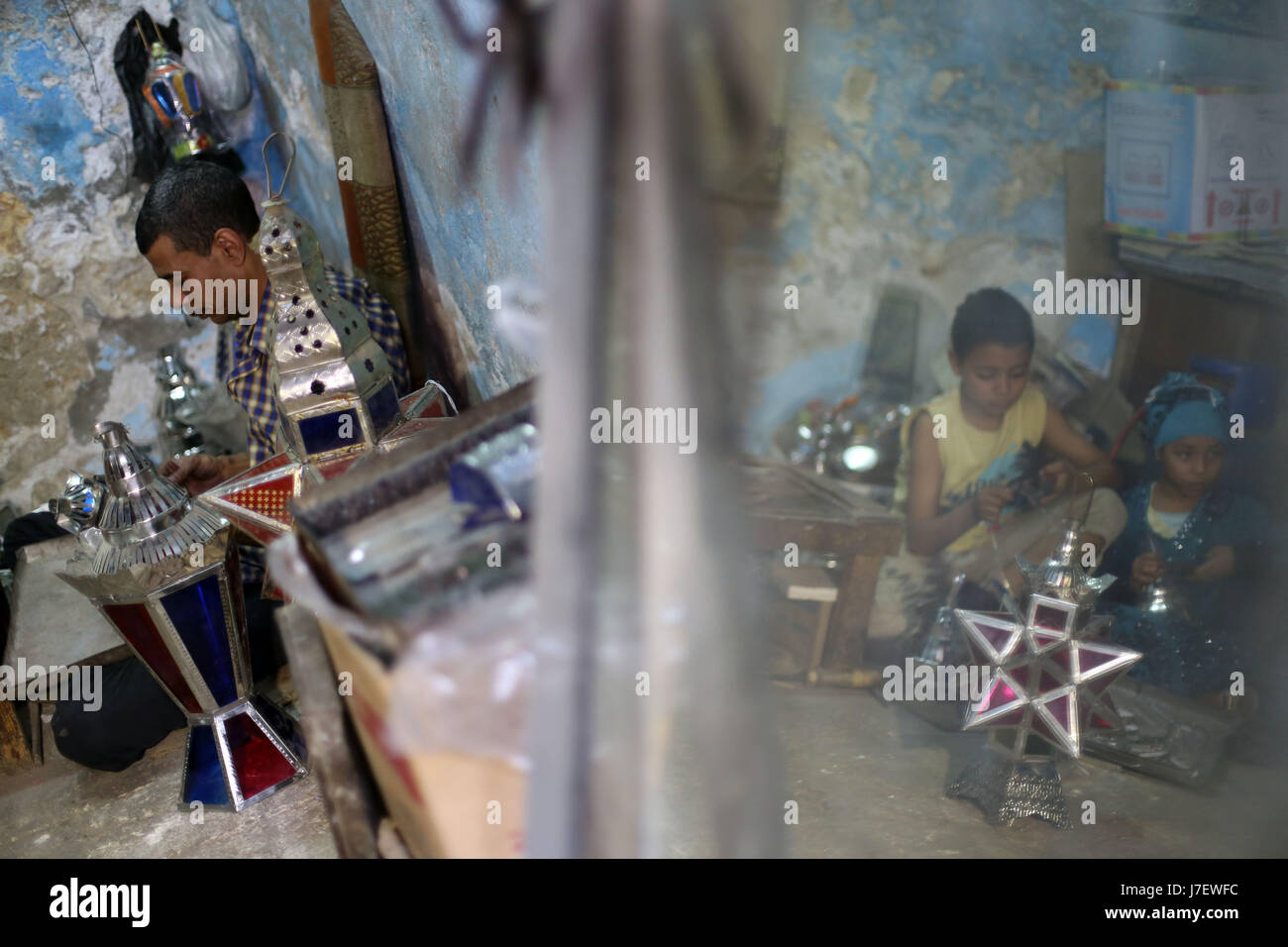 (170524)--Kairo, 24. Mai 2017 (Xinhua)--Hussein Sayyid (L) und seine Kinder machen traditionelle handgefertigte Laternen in seiner Werkstatt in Kairo, Ägypten, am 20. Mai 2017. Befindet sich in einem alten Gebäude in einer Straße voller Workshops in Al-Qalaa, die "die Zitadelle" auf Arabisch bedeutet unter Bezugnahme auf Kairos Saladin-Zitadelle, produziert von Sayyid Workshop bunte handgemachte Glas und Metall-Laternen in verschiedenen Größen, auf Arabisch als "Fanoos", angezeigt auf steht außerhalb der Werkstatt bekannt. Traditionelle handgefertigte Laternen dienen in der Regel als Dekoration in Ägypten während der jährlichen Monat Ramadan. (Xinhua/Ahmed Gomaa) Stockfoto