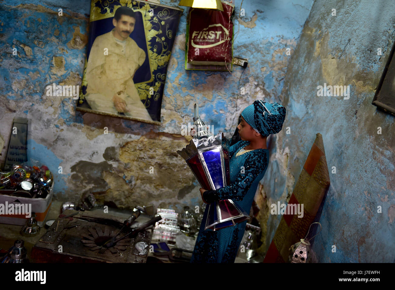 (170524)--Kairo, 24. Mai 2017 (Xinhua)--Hussein Sayyid Tochter prüft eine neu gemachte Laterne in ihres Vaters Werkstatt in Kairo, Ägypten, am 20. Mai 2017. Befindet sich in einem alten Gebäude in einer Straße voller Workshops in Al-Qalaa, die "die Zitadelle" auf Arabisch bedeutet unter Bezugnahme auf Kairos Saladin-Zitadelle, produziert von Sayyid Workshop bunte handgemachte Glas und Metall-Laternen in verschiedenen Größen, auf Arabisch als "Fanoos", angezeigt auf steht außerhalb der Werkstatt bekannt. Traditionelle handgefertigte Laternen dienen in der Regel als Dekoration in Ägypten während der jährlichen Monat Ramadan. (Xinhua/Zhao Dingzhe) Stockfoto