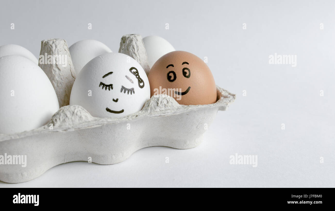 Eiern mit lustigen Gesichtern im Paket auf einem weißen Hintergrund. Ostern-Konzept-Foto. Eiern. Gesichter auf den Eiern Stockfoto