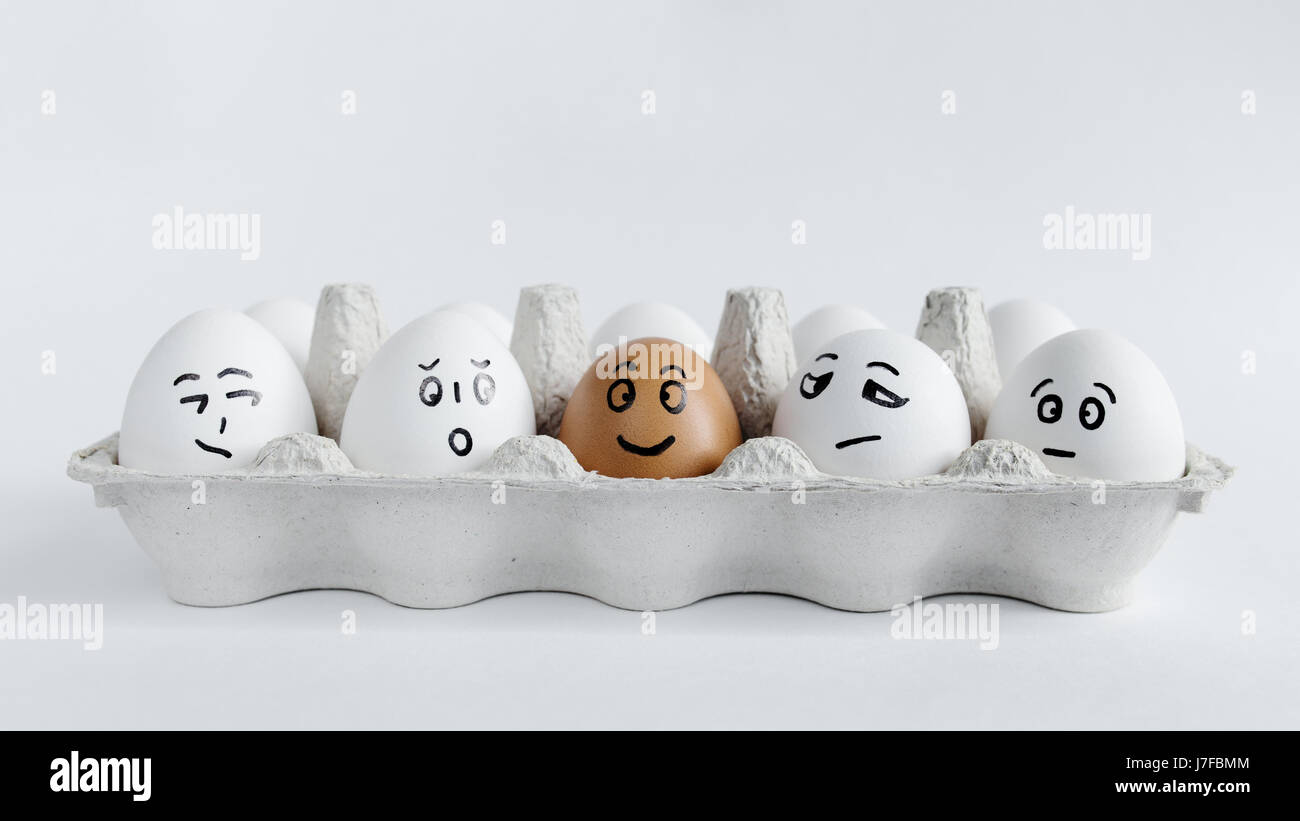 Eiern mit lustigen Gesichtern im Paket auf einem weißen Hintergrund. Ostern-Konzept-Foto. Eiern. Gesichter auf den Eiern Stockfoto