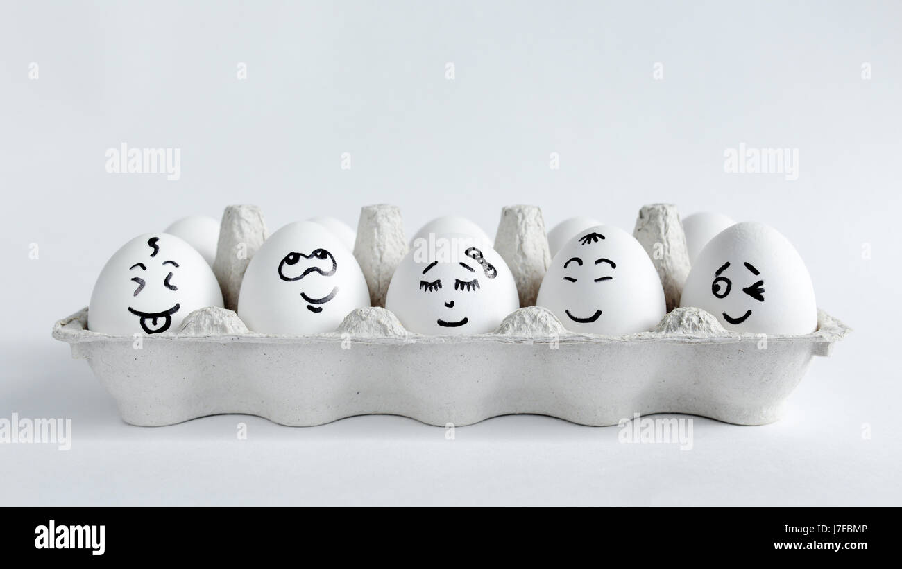 Eiern mit lustigen Gesichtern im Paket auf einem weißen Hintergrund. Ostern-Konzept-Foto. Eiern. Gesichter auf den Eiern Stockfoto