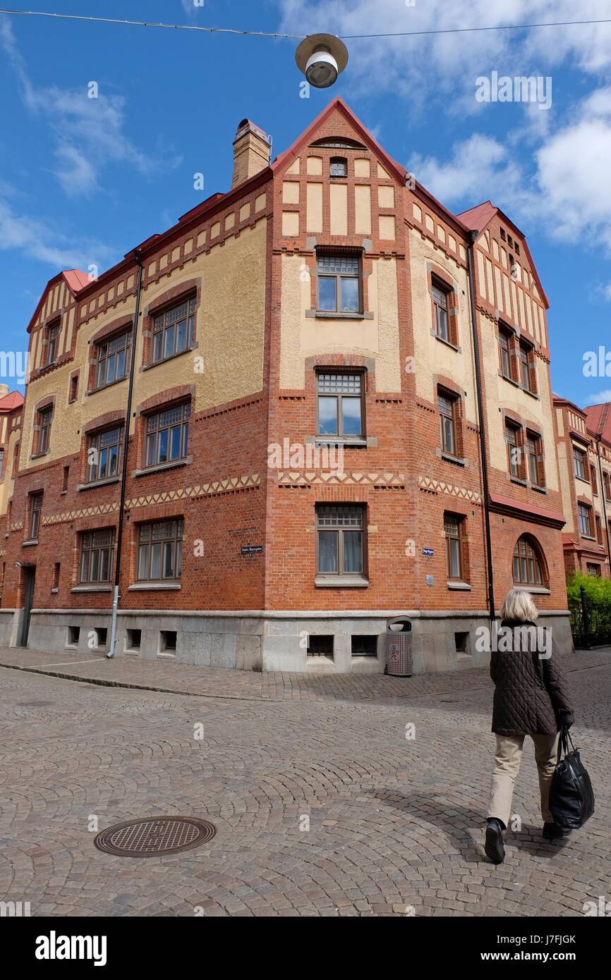 Göteborg, Schweden - Mai 2017: Backsteingebäude und eine Person zu Fuß auf einer Straße in Göteborg, Schweden Stockfoto