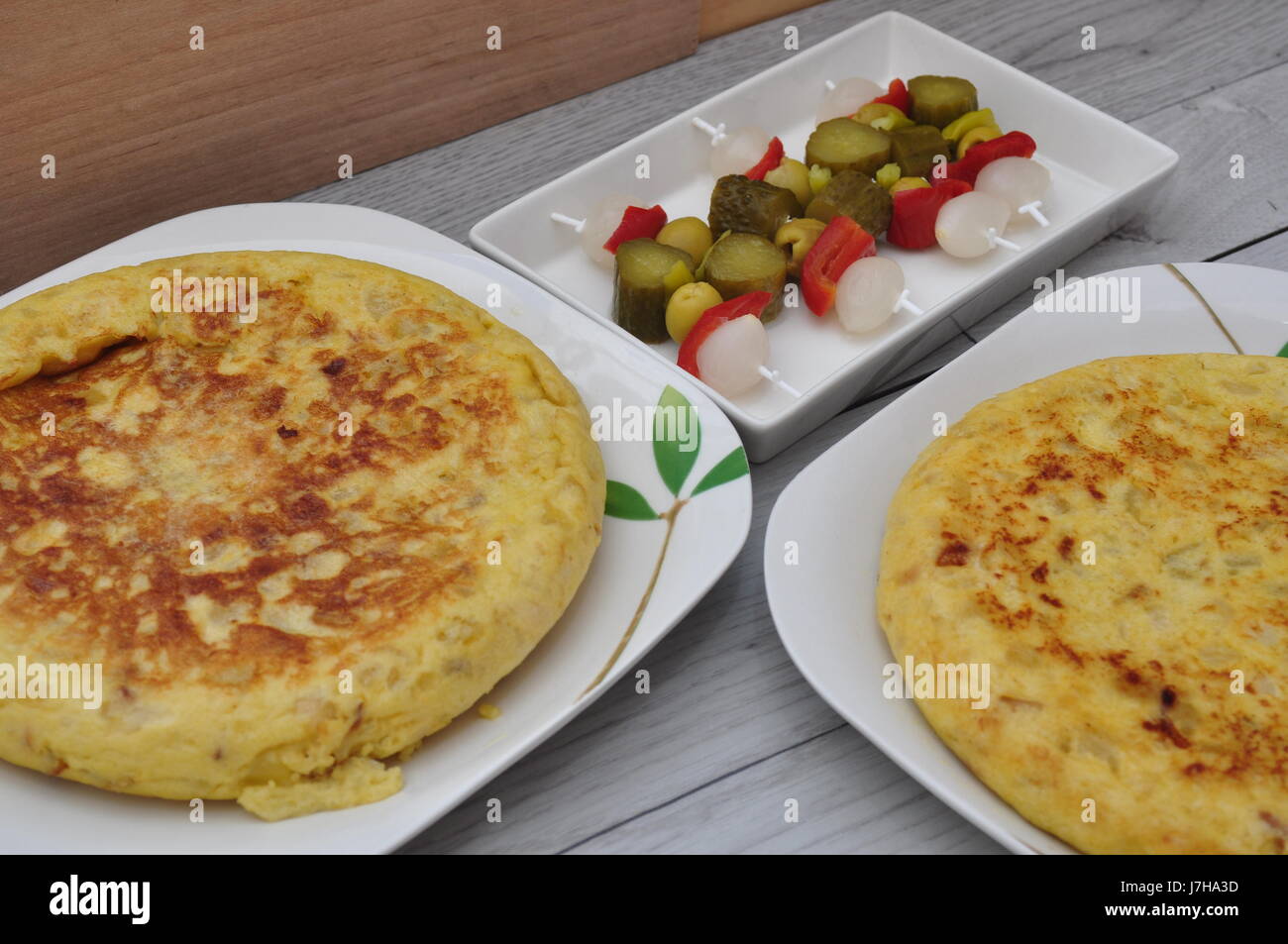 Kartoffel-Tortillas auf einer Platte und pikantem Gemüse ...