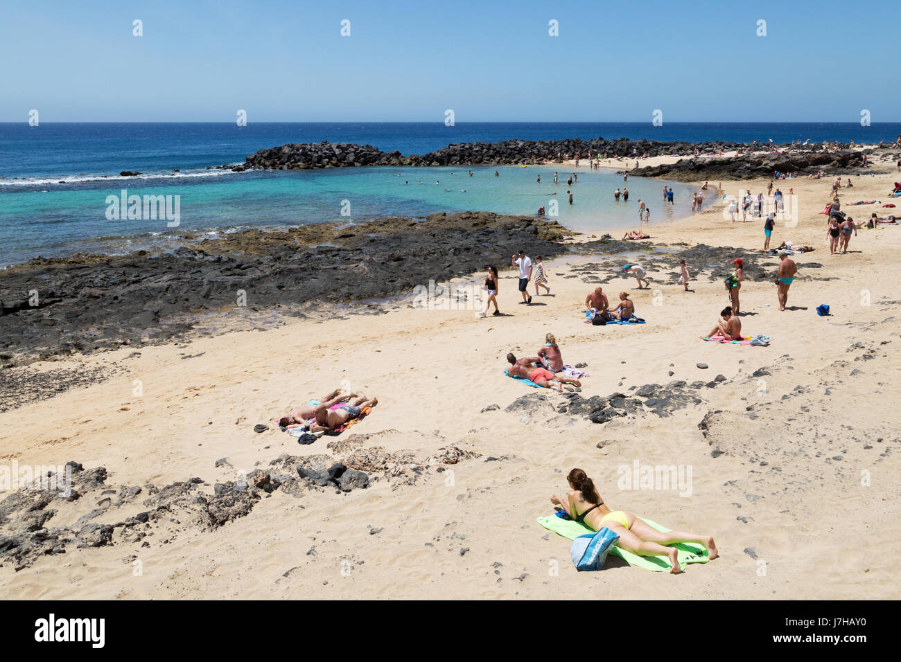 Menschen Sonnenbaden auf einem Lanzarote beach - Costa Teguise, Lanzarote, Kanarische Inseln, Europa Stockfoto