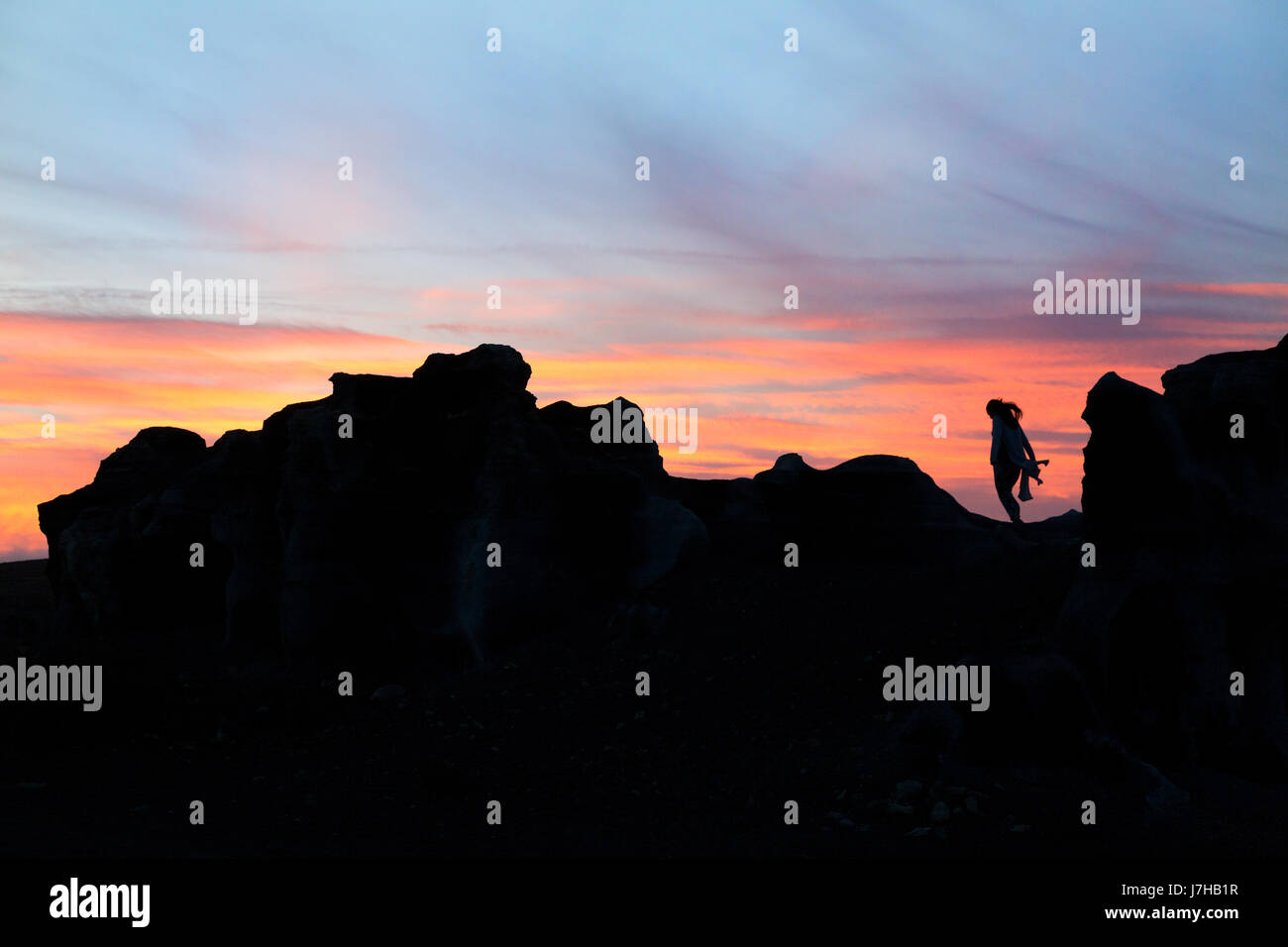 Lanzarote-Sonnenuntergang - eine Frau steht auf einem vulkanischen Felsen bei Sonnenuntergang, Lanzarote, Kanarische Inseln Europas. Konzept / konzeptionelle Bild Stockfoto