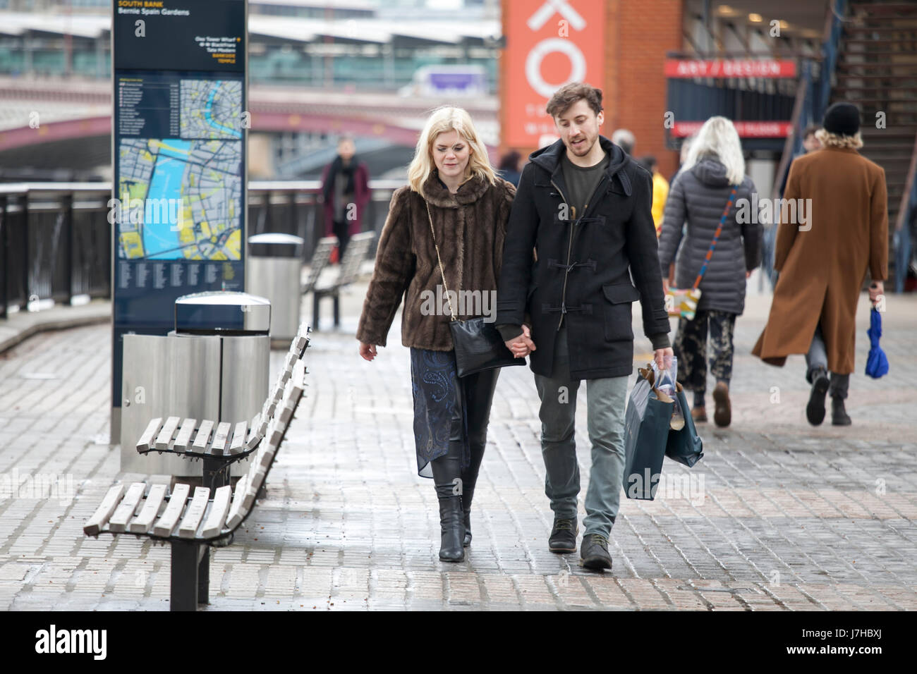 LONDON, ENGLAND - 12. März 2017 glückliche Paar, Hand in Hand, zu Fuß entlang der Uferpromenade Stockfoto