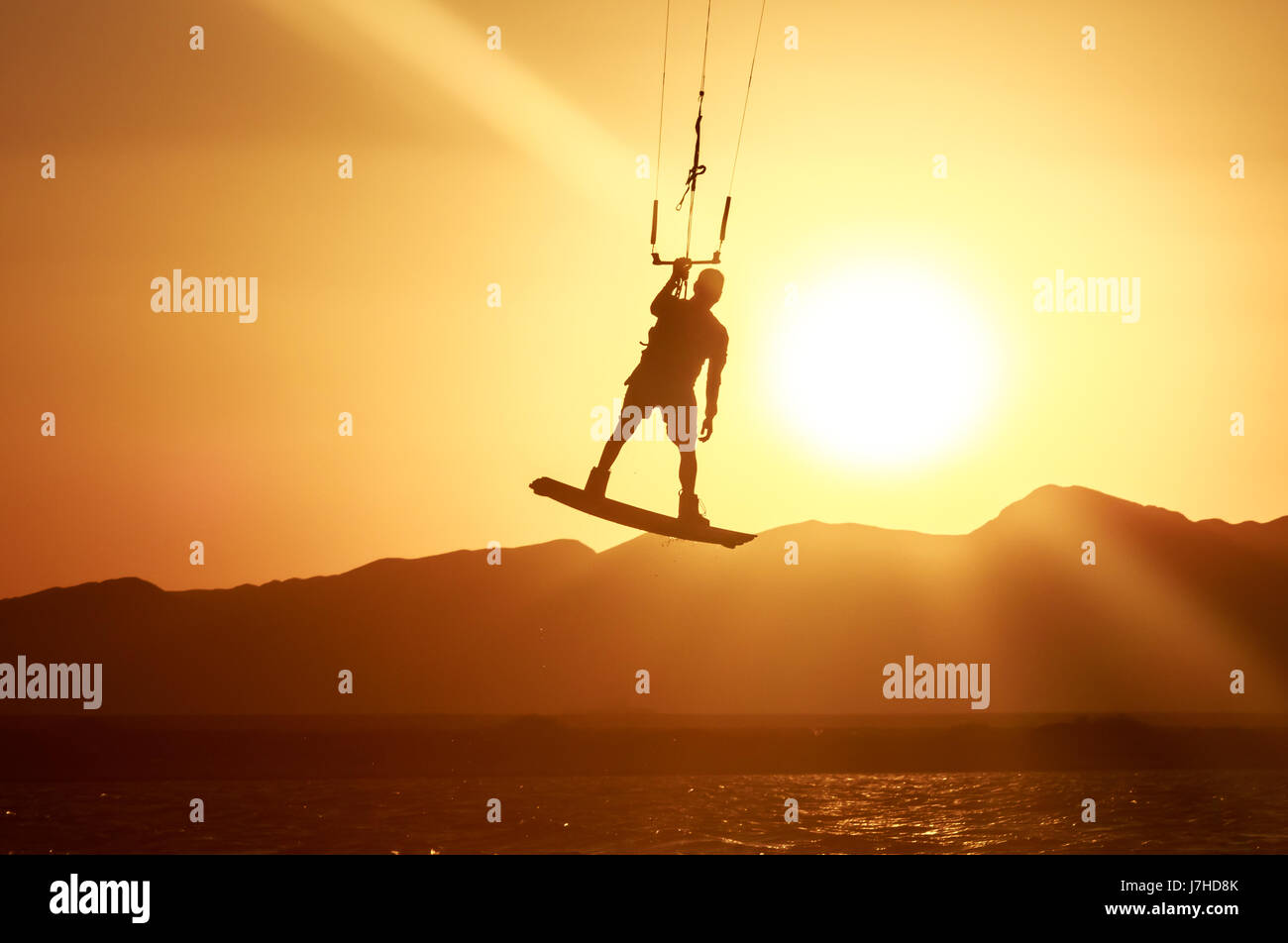Kite Boarder Sportler mit Kite unter Sonnenuntergang Sonne, Freestyle Kiteboarding Reiter auf den Abend-Kite-Session, Sonnenuntergang im Meer, extreme watersports Stockfoto