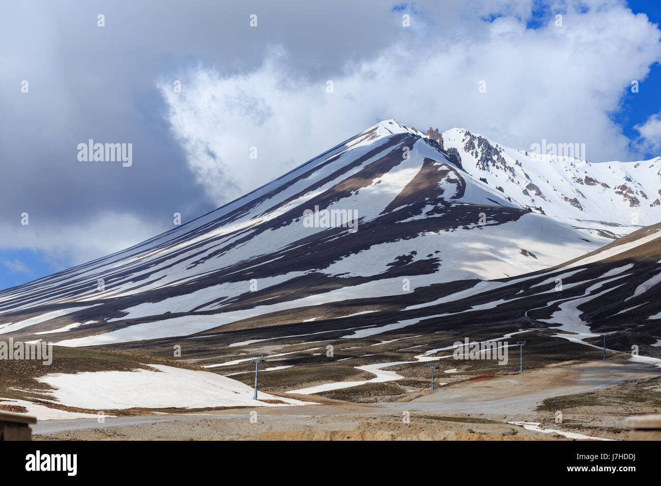 Horizontalen Schuss von Schnee bedeckt Erjiyes Berggipfel mit Seilbahn Säulen im Frühjahr mit einigen Schneeschmelze Stockfoto