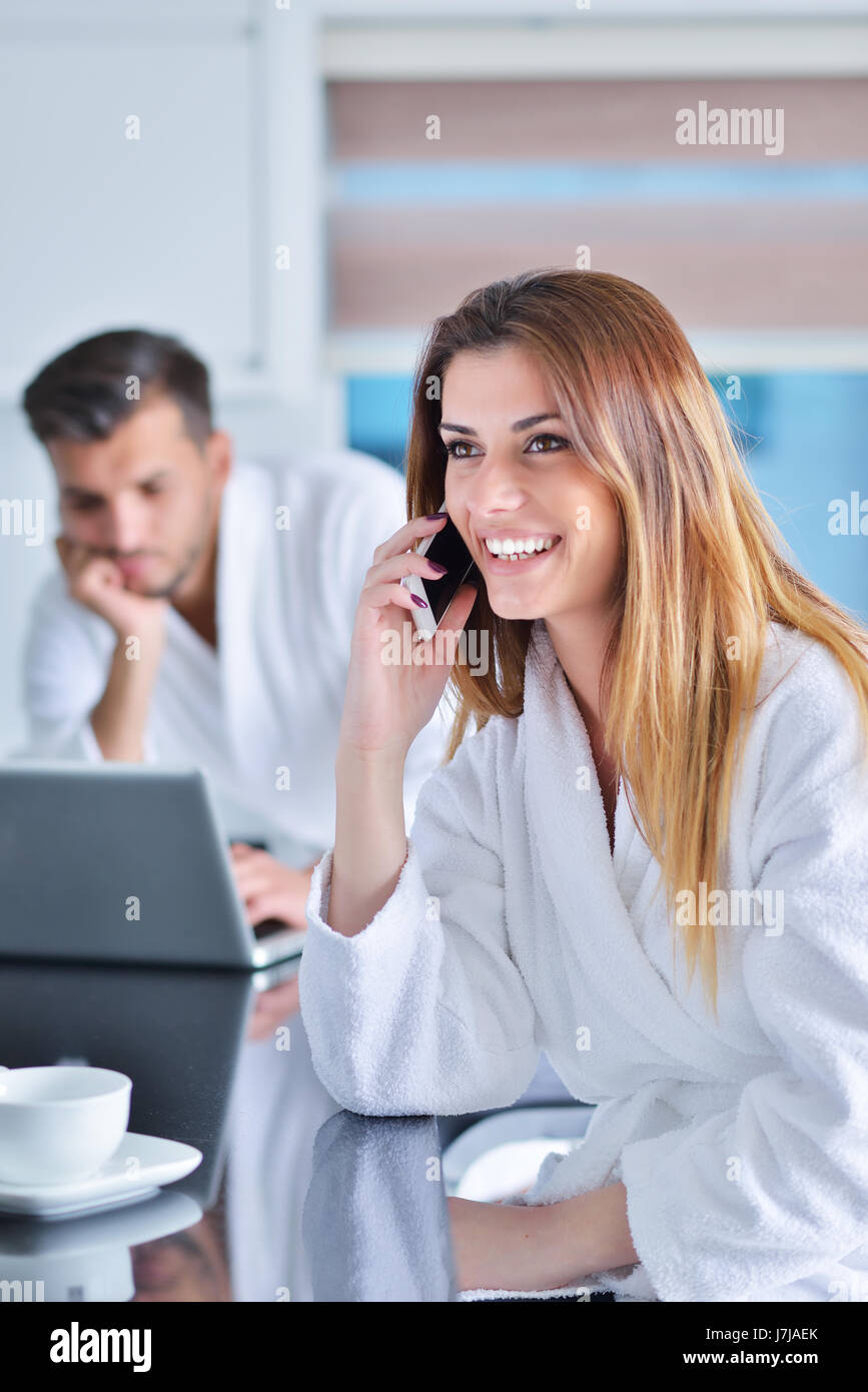 Frau trägt einen weißen Bademantel mit laptop Stockfoto