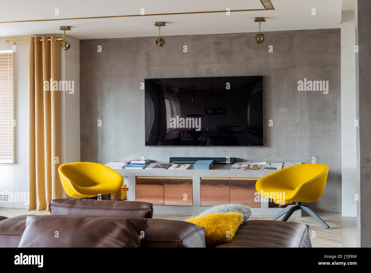 Paar leuchtend gelbe Stühle mit Wand montiert Bildschirm für Heimkino Stockfoto