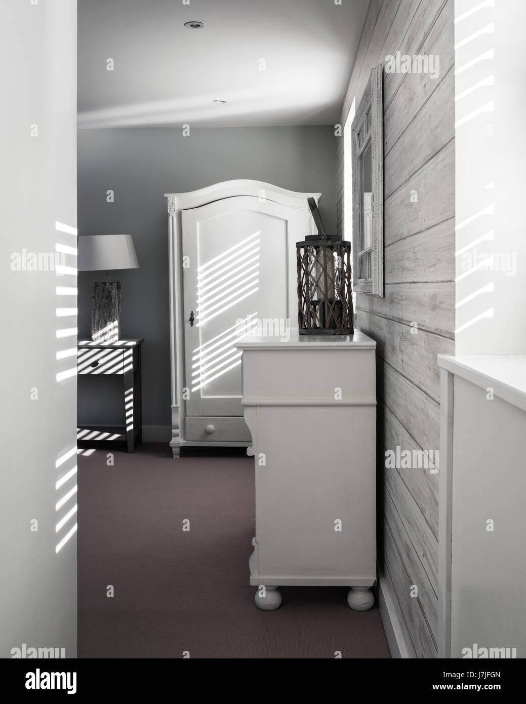 Licht, das in Schlafzimmer mit Andrew Martin Holz Tapete. die Wände sind bemalt in Oberlicht Estate Emulsion von Farrow & Ball Stockfoto