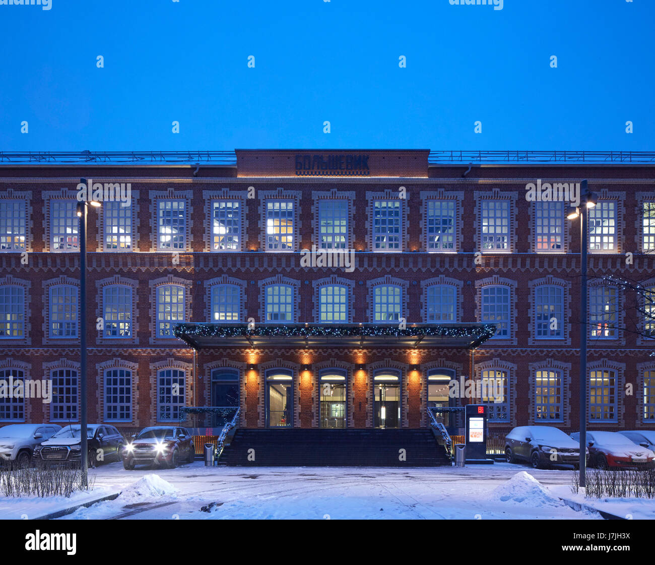 Frontale Außenansicht in der Abenddämmerung. Die bolschewistische Fabrik, Moskau, Russland. Architekt: John Mcaslan und Partner, 2016. Stockfoto