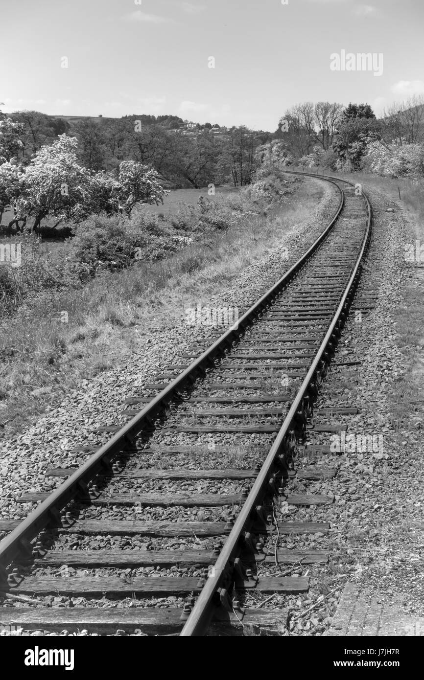 Eine eingleisig ländlichen normalspurigen Bahnstrecke auf einer Kurve in schwarz / weiß Stockfoto
