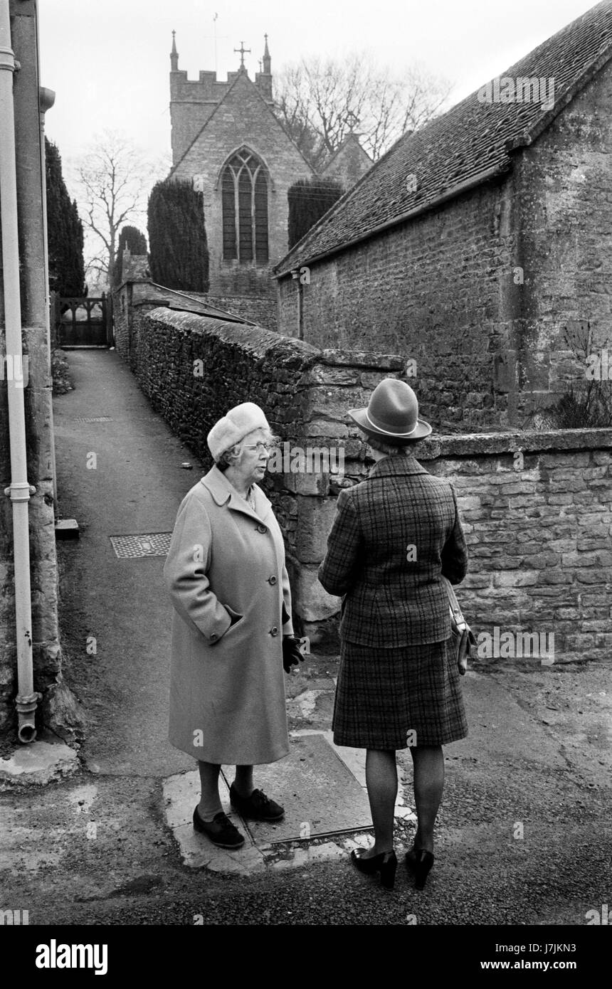 Freunde chatten, Dorf Landleben in den 1970er Jahren Gloucestershire UK. Die Cotswolds. Lower und Upper Slaughter sind Zwillingsdörfer am River Eye und sind als die Schlachter bekannt. 1975. HOMER SYKES Stockfoto