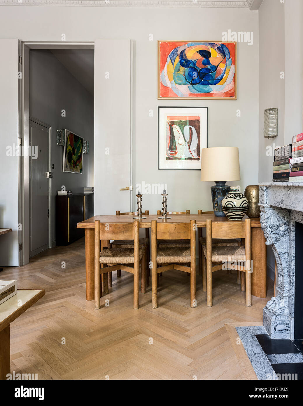 Holztisch und Stühle von Charlotte Perriand mit Kerze von Jean Despres Stockfoto