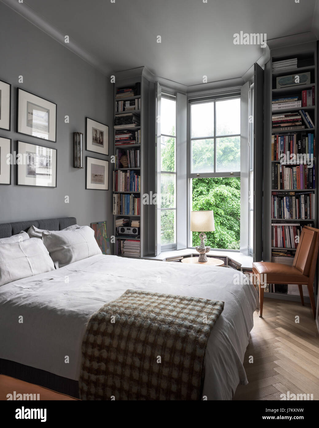 Beruhigen Sie Grautöne zu und buchen Sie Regale in Schlafzimmer mit 1940er Jahre Murano-Glas-Wandleuchten Stockfoto