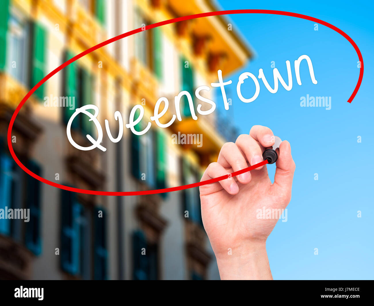 Hand des Mannes Queenstown mit schwarzem Filzstift auf Bildschirm zu schreiben. Isoliert auf Stadt. Wirtschaft, Technologie, Internet-Konzept. Stock Foto Stockfoto