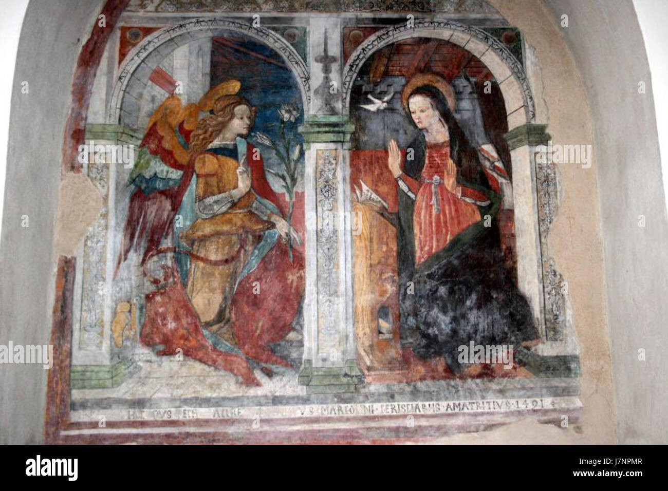 Die Verkündigungsszene in der Kirche Sant’Agostino in Amatrice zeigt den Engel Gabriel, der der Jungfrau Maria ankündigt, dass sie den Sohn Gottes empfangen wird. Das Kunstwerk folgt der traditionellen religiösen Ikonographie und betont die göttliche Botschaft und Marias Akzeptanz ihrer Rolle in der Heilsgeschichte. Stockfoto