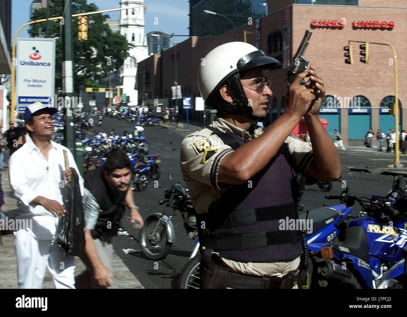 Ein Polizist hält seine Waffe bei Zusammenstößen in Caracas 11. April 2002. Mindestens zehn Menschen wurden getötet und mehr als 80 verletzt wie shooting ausbrach Stockfoto