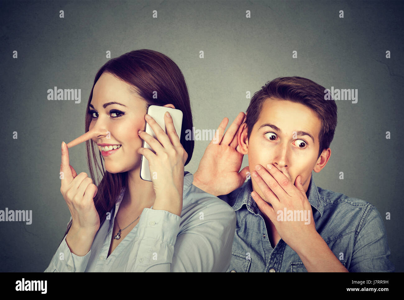 Eine betrügende Freundin. Neugierig Mann heimlich zuhören eine glückliche Frau Lügner Gespräch am Handy mit Ihrem geliebten auf grauem Hintergrund Stockfoto