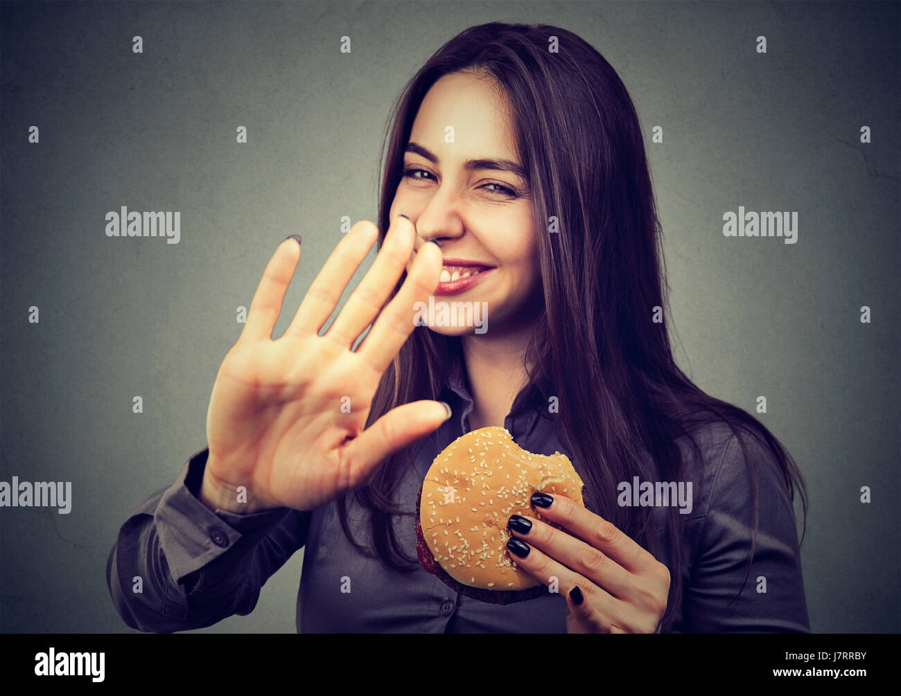 Frau mit Hamburger Ablehnung beraten über gesunde Ernährung Stockfoto