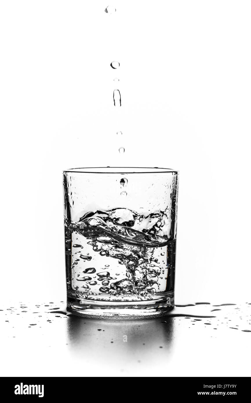 Flüssigkeit in ein Glas auf einem weißen Hintergrund gießen Stockfoto
