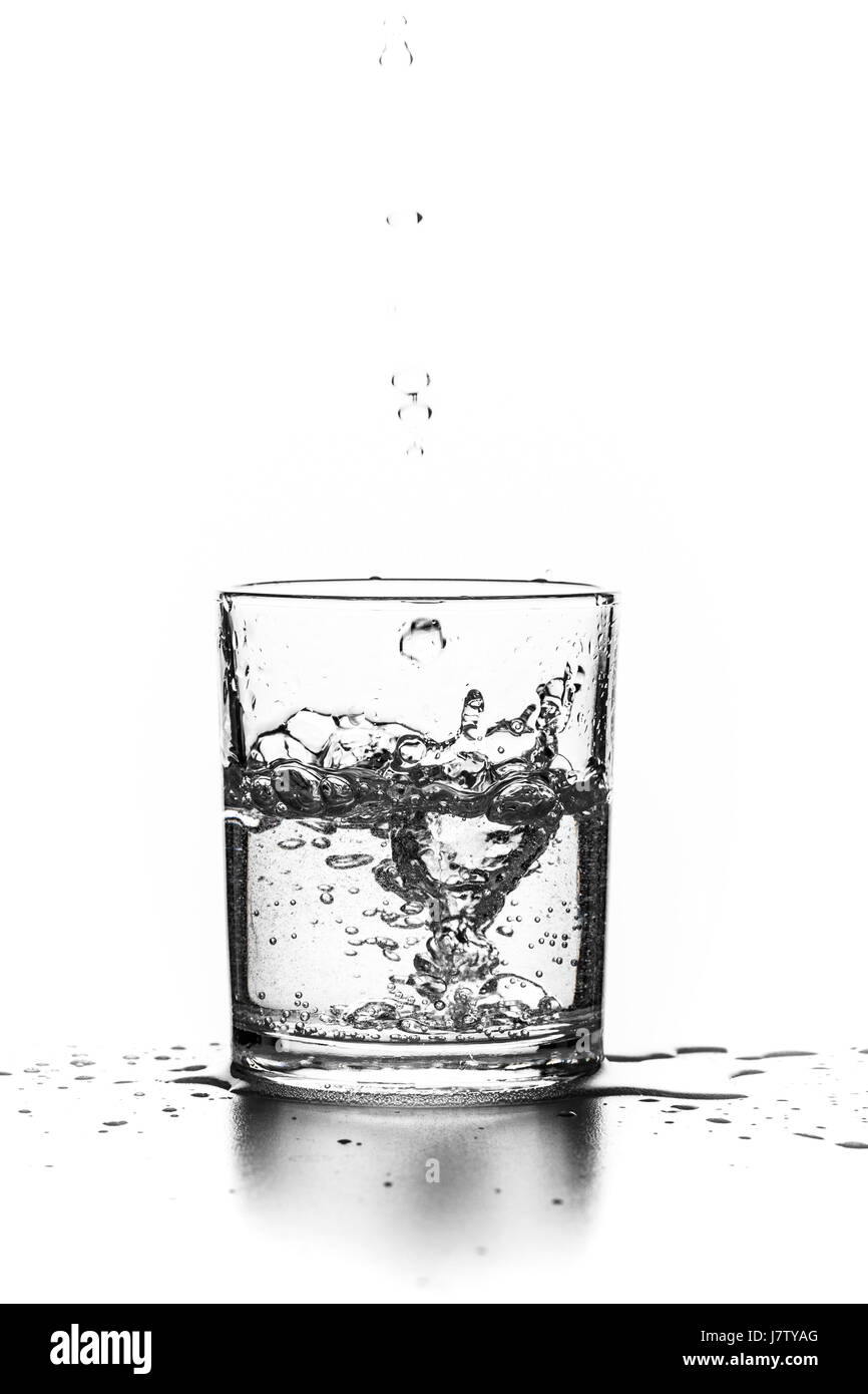 Flüssigkeit in ein Glas auf einem weißen Hintergrund gießen Stockfoto