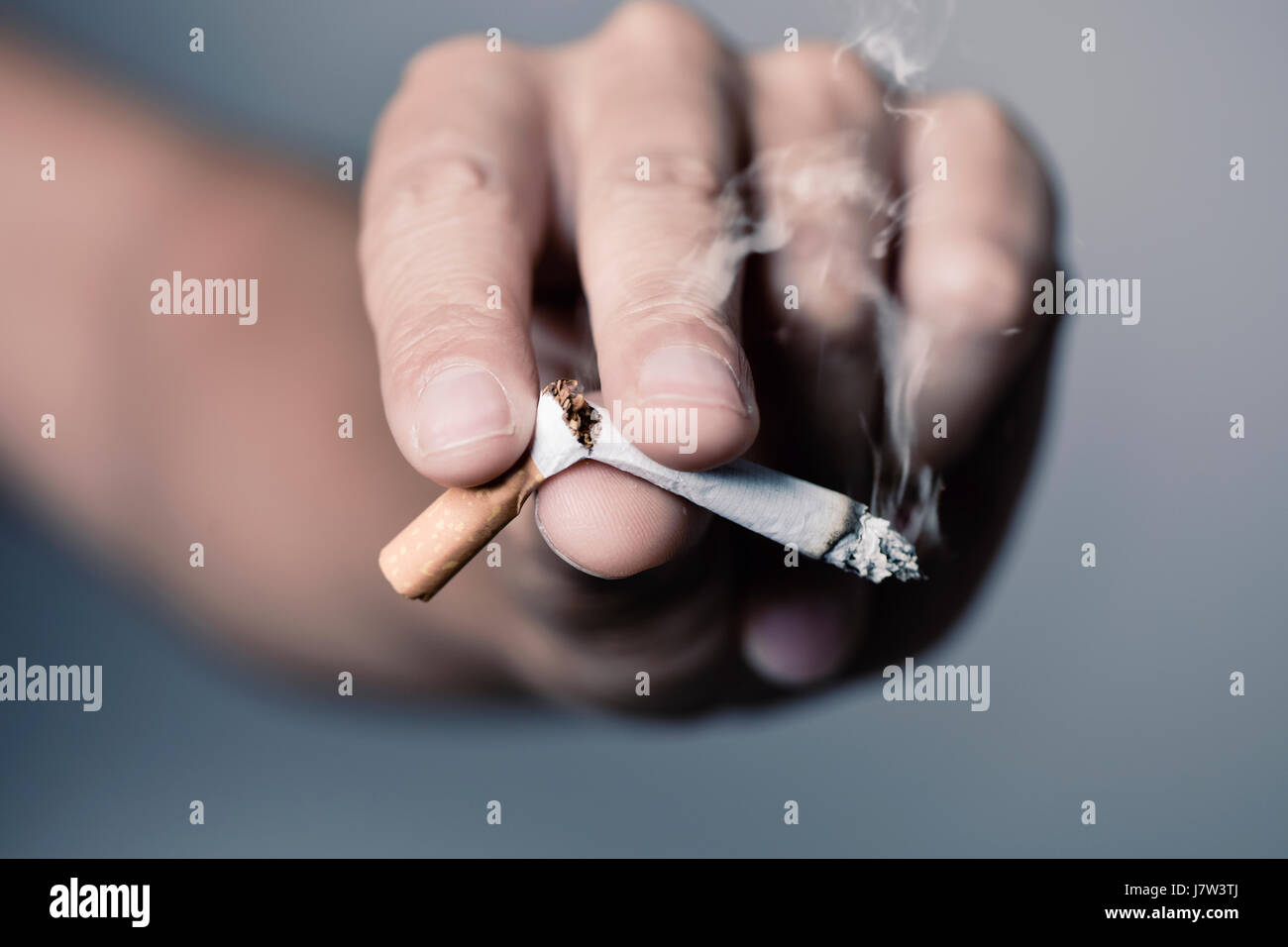 Nahaufnahme der Hand von einem kaukasischen Jüngling eine brennende Zigarette mit seinen Fingern zu brechen Stockfoto Nahaufnahme der Hand von einem kaukasischen Jüngling eine brennende Zigarette mit seinen Fingern zu brechen Stockfoto
