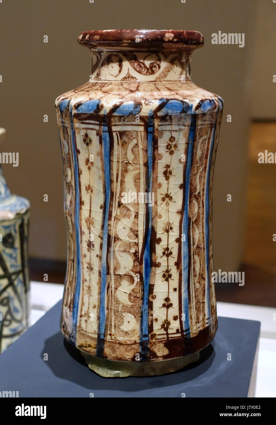 Dieses Bild zeigt einen Albarello aus Syrien aus dem 13. Jahrhundert, speziell aus Raqqa, der aus frittiertem Geschirr gefertigt und mit goldenem Glanz und Blau bemalt wurde und im Aga Khan Museum in Toronto, Kanada, untergebracht ist. Stockfoto