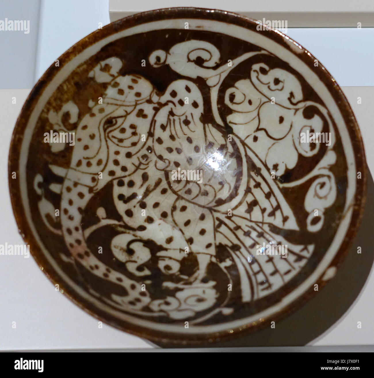 Eine Schüssel aus dem 13. Jahrhundert mit glänzend bemalten Frittierwaren aus dem Iran mit einer mythischen Kreatur, die im Aga Khan Museum in Toronto, Kanada, untergebracht ist. Stockfoto