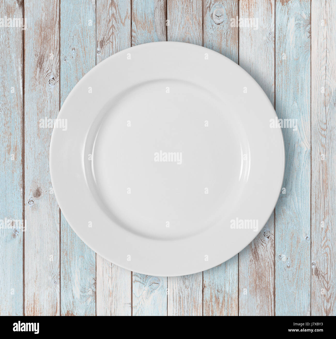 weiße leere Teller auf blauen Holztisch Stockfoto