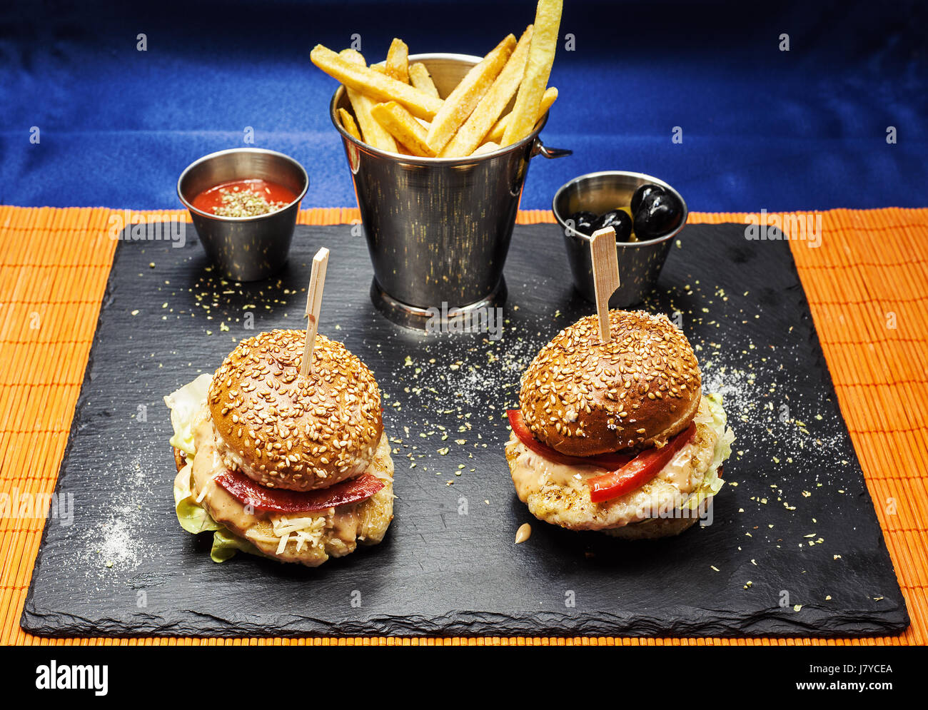 Zwei Burger und Pommes auf schwarze Keramik Board. Stockfoto