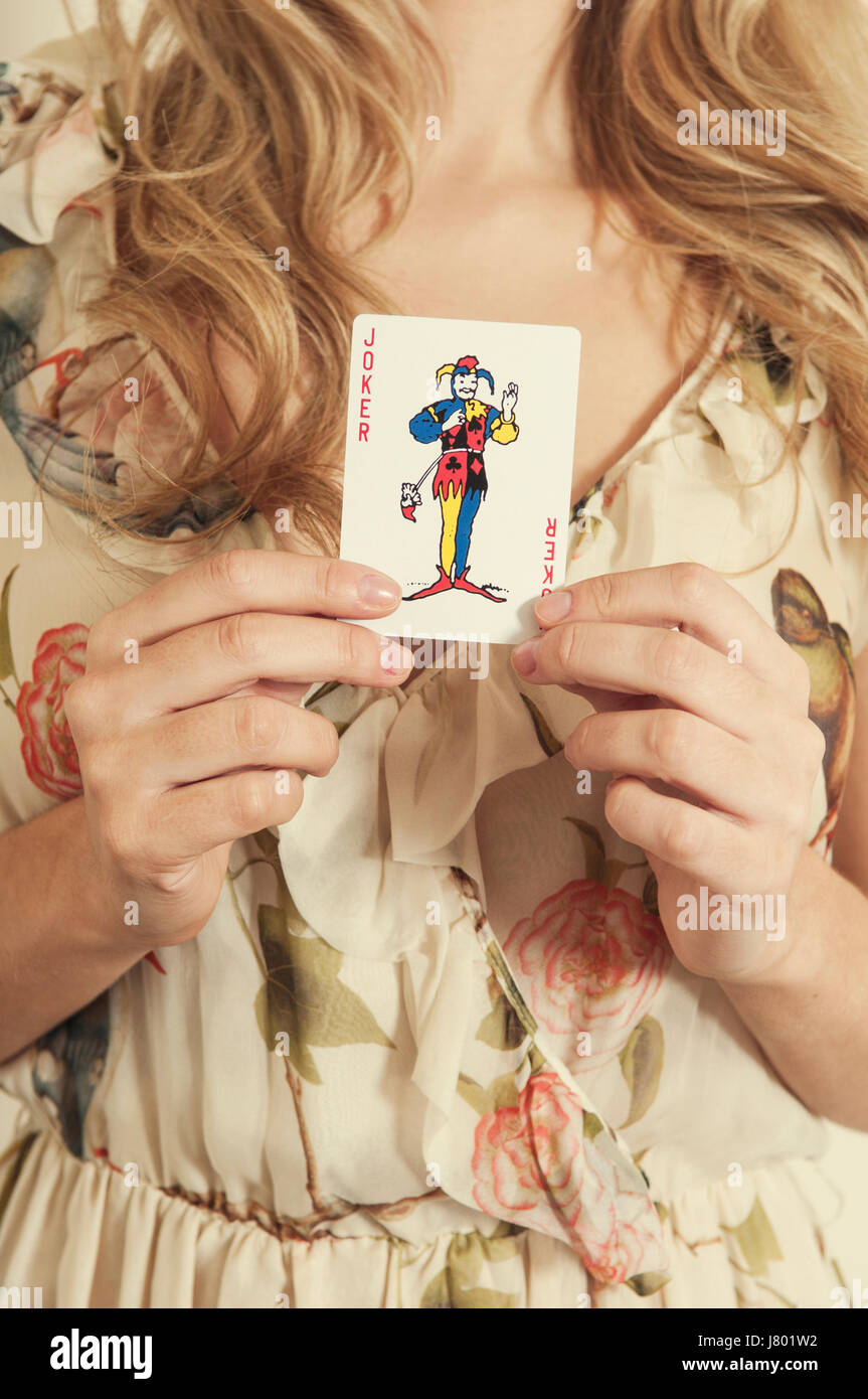 Frau hält eine Spielkarte jocker Stockfoto