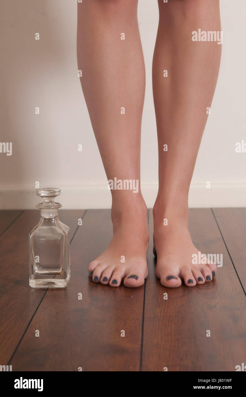 Frau die Füße stehen neben einem leeren Parfüm-Flasche Stockfoto