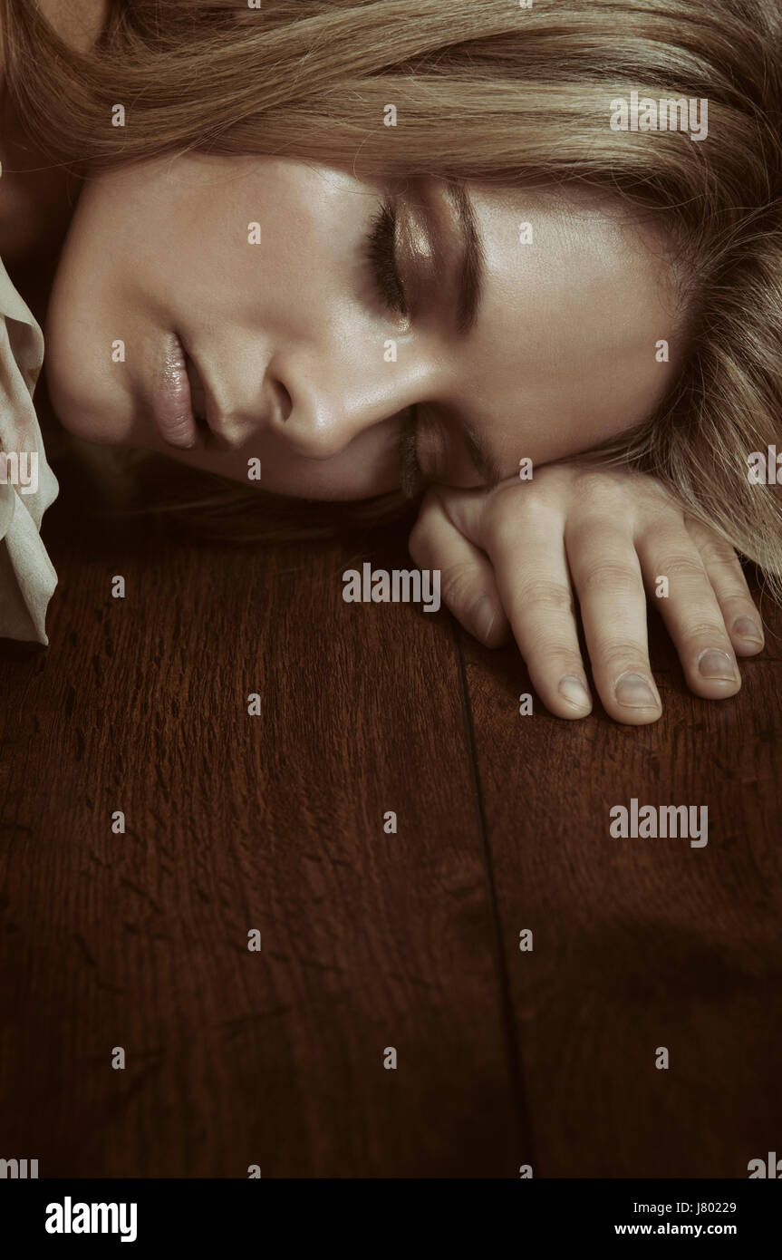 Müde, junge Frau auf dem Boden schlafen Stockfoto
