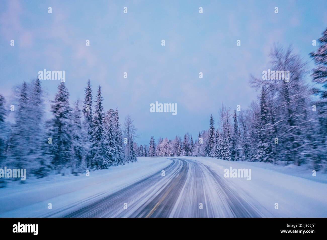 Entfernten Winter Weg durch Schnee bedeckt Waldbäume gegen blauen Himmel, Lappland, Finnland Stockfoto