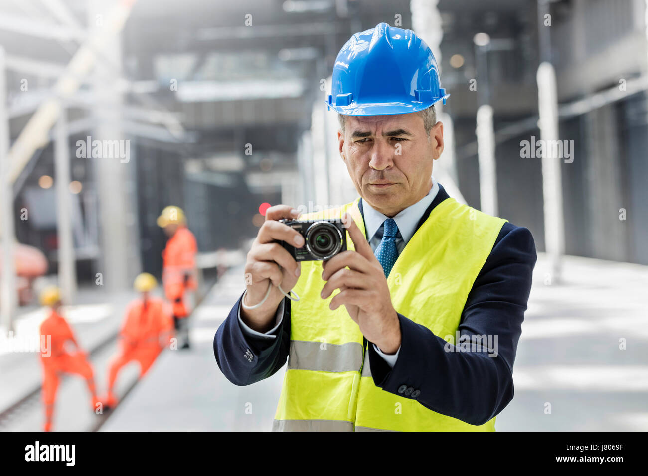 Geschäftsmann mit Digitalkamera auf Baustelle Stockfoto