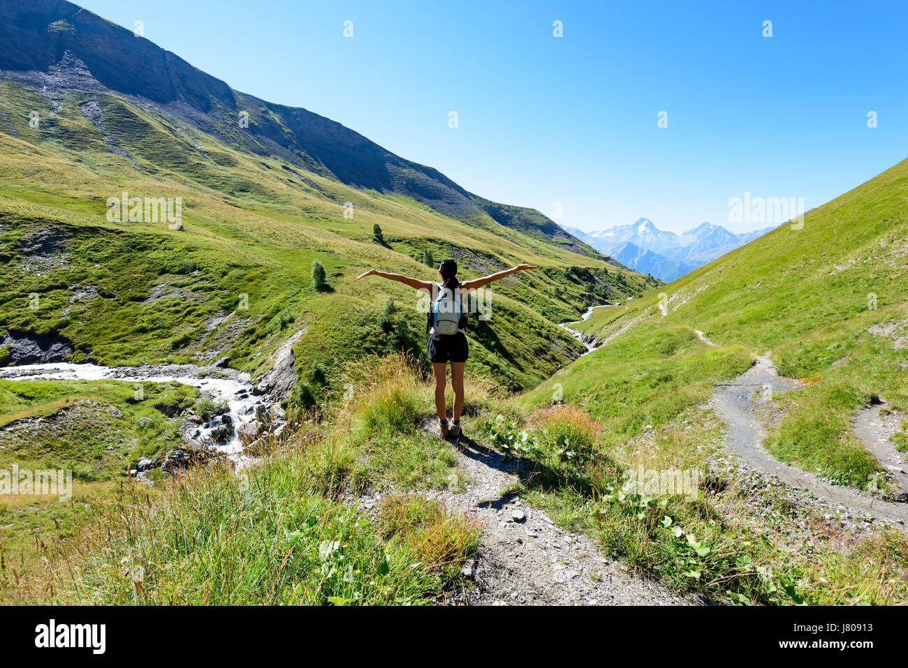 Frau stehend auf Spur in den Bergen in den Alpen und heben ihre Arme, Naturpark Oisans, Frankreich, Europa Stockfoto
