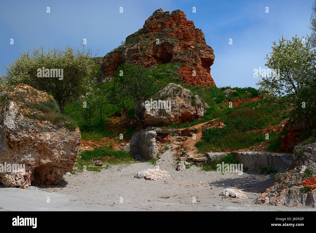 Der schöne Felsen an der Küste des Schwarzen Meeres im Frühling in der Nähe von Kap Kaliakra in Bulgarien, eine feinere orange rote Klippe mag ein Bergtroll am Meer Stockfoto