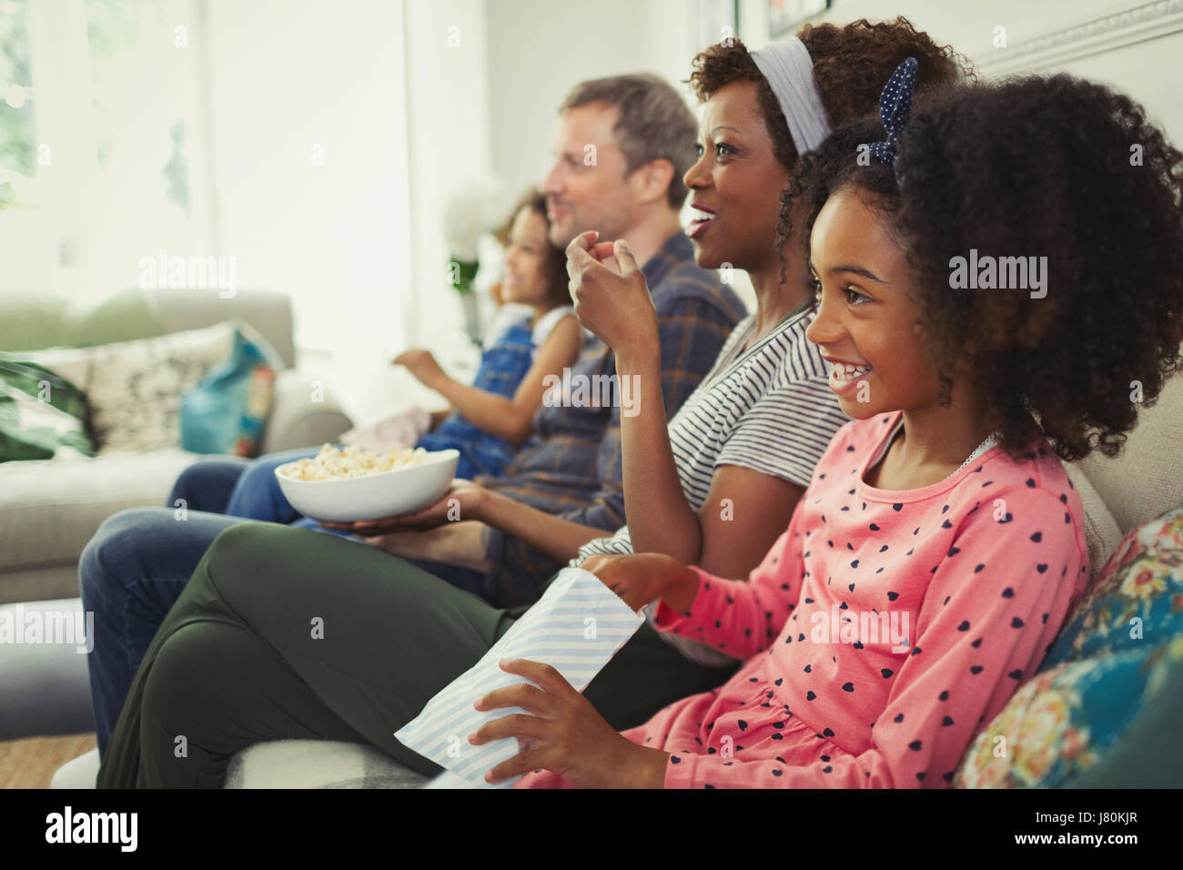 Junge multiethnischen Familie Film und Essen Popcorn auf sofa Stockfoto
